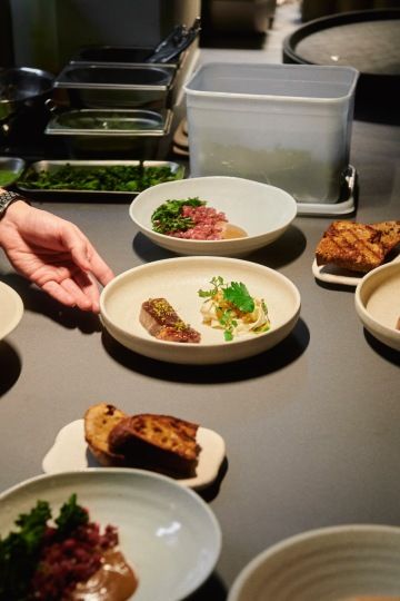 Alma restaurant hand off with plates being assembled